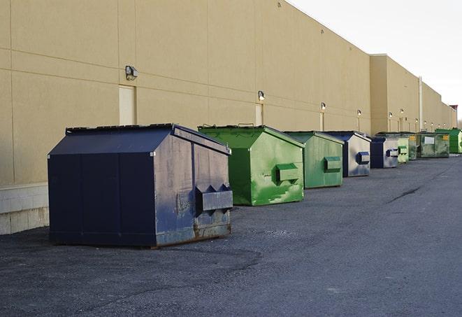 a construction worker disposing of debris into a dumpster in Colonia NJ